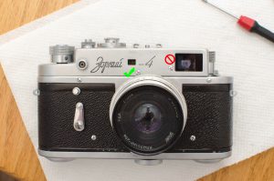The screw to the left of the main viewfinder window hides the horizontal rangefinder adjustment on the Zorki 4.
